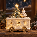 Light-up Christmas train car with green and white trees, a glowing star topper and gold-tone wheels.