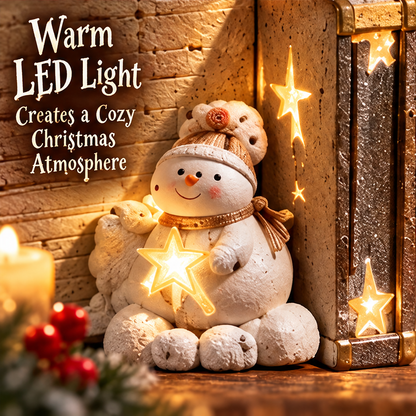 Angled view showing star openings, gold-tone edging and the snowman beside the book-shaped decoration.